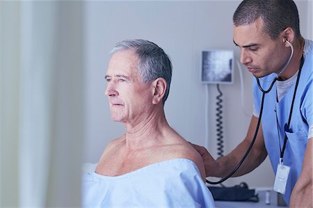 senior nurse care - Male nurse listening to senior male patient back with stethoscope Stock Photo - Premium Royalty-Free, Code: 649-08745404