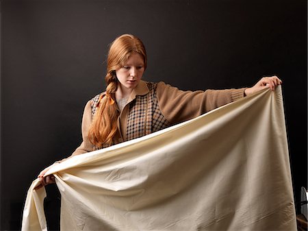 Young female designer inspecting rolled fabric Photographie de stock - Premium Libres de Droits, Code: 649-08745561