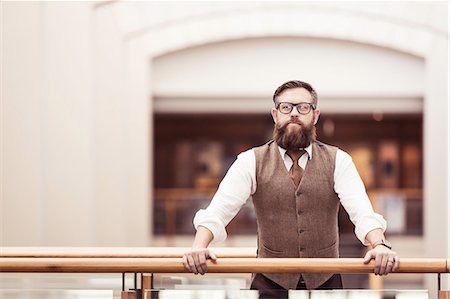 Portrait of bearded businessman wearing tweed waistcoat on office balcony Stock Photo - Premium Royalty-Free, Code: 649-08745609