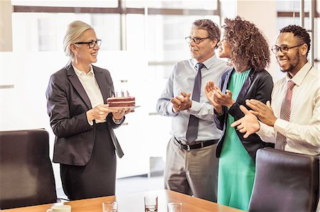 simsearch:649-08117902,k - Mature woman presenting cake with candles to business team in boardroom Stock Photo - Premium Royalty-Free, Code: 649-08745633