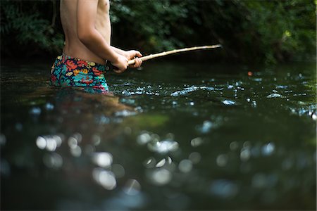 shirtless, boy - Cropped view of boy waist deep in water holding stick Stock Photo - Premium Royalty-Free, Code: 649-08745641