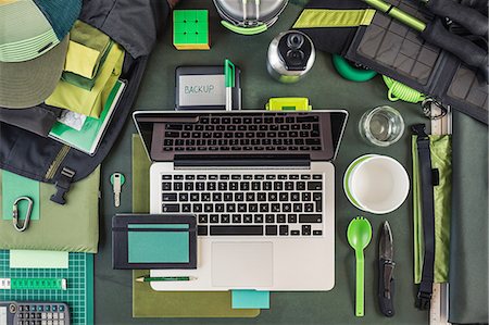 Overhead view of laptop, external hard drive and hiking equipment, green Stock Photo - Premium Royalty-Free, Code: 649-08745759