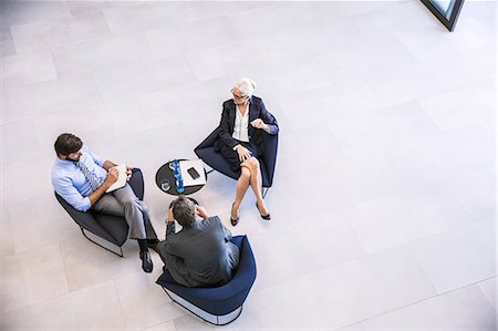 simsearch:649-03774045,k - High angle view of businesswoman and men meeting in office atrium Photographie de stock - Premium Libres de Droits, Code: 649-08765784