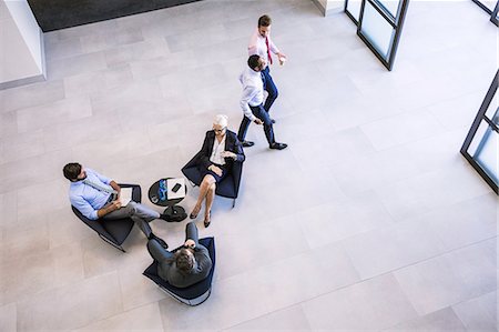 sprecare - High angle view of businesswoman and men meeting in office atrium Stock Photo - Premium Royalty-Free, Code: 649-08765786