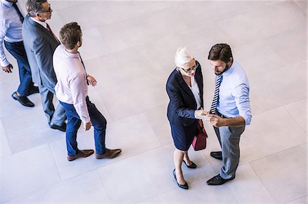 simsearch:649-07064422,k - High angle view of two businessman and woman reading smartphone text in office atrium Stockbilder - Premium RF Lizenzfrei, Bildnummer: 649-08765789