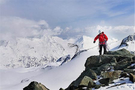 saas-fee - Man on top of snow covered mountain throwing climbing rope, Saas Fee, Switzerland Stock Photo - Premium Royalty-Free, Code: 649-08765883