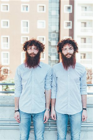 Portrait of identical male hipster twins standing on apartment roof terrace Stock Photo - Premium Royalty-Free, Code: 649-08765956