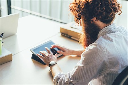 simsearch:614-08982929,k - Young male hipster with red hair and beard using digital tablet touchscreen at desk Stock Photo - Premium Royalty-Free, Code: 649-08765959