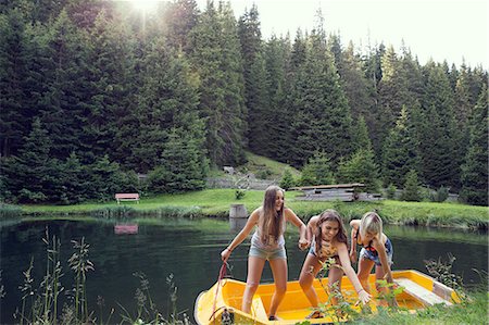 simsearch:649-08824142,k - Three adult female friends pushing rowing boat from lakeside, Sattelbergalm, Tirol, Austria Fotografie stock - Premium Royalty-Free, Codice: 649-08766006