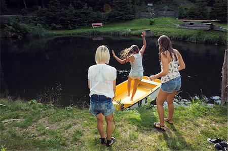 simsearch:649-08824142,k - Three adult female friends jumping into rowing boat on lake, Sattelbergalm, Tirol, Austria Fotografie stock - Premium Royalty-Free, Codice: 649-08766003