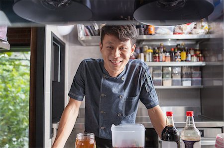 simsearch:649-08766085,k - Portrait of chef in commercial kitchen looking at camera smiling Photographie de stock - Premium Libres de Droits, Code: 649-08766087