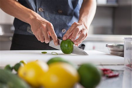 simsearch:649-08766085,k - Cropped view of man slicing limes Photographie de stock - Premium Libres de Droits, Code: 649-08766095