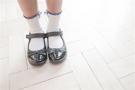 Cropped shot of schoolgirl wearing shoes and ankle socks standing on parquet floor Stock Photo - Premium Royalty-Free, Code: 649-08766171