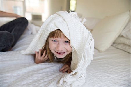 Young girl peeking head out from under blanket on bed Foto de stock - Sin royalties Premium, Código: 649-08766232