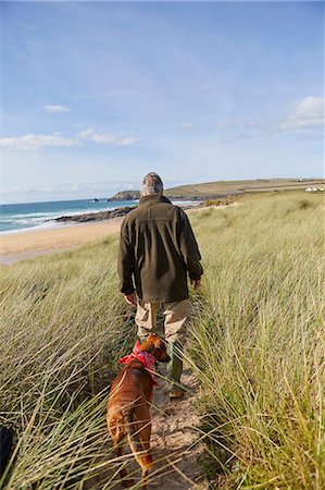 dog man - Man walking pet dog on sand dunes, Constantine Bay, Cornwall, UK Stock Photo - Premium Royalty-Free, Code: 649-08766296