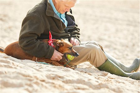 discipliner - Man and dog sitting on beach, Constantine Bay, Cornwall, UK Photographie de stock - Premium Libres de Droits, Code: 649-08766301