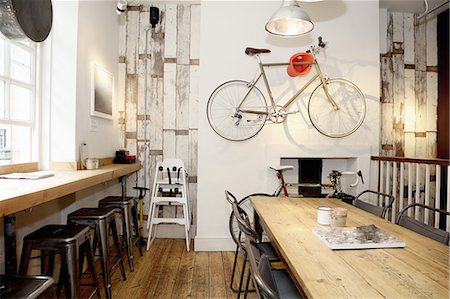 Quirky coffee shop interior with bicycle on wall Stock Photo - Premium Royalty-Free, Code: 649-08766447