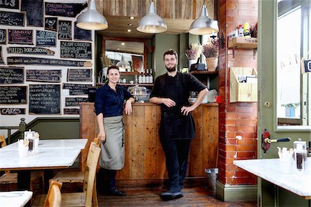 Portrait of male and female baristas leaning on counter of independent coffee shop Foto de stock - Sin royalties Premium, Código: 649-08766450