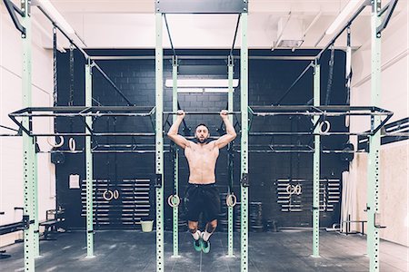 front view of a train - Young male cross trainer training on exercise bar in gym Stock Photo - Premium Royalty-Free, Code: 649-08766513