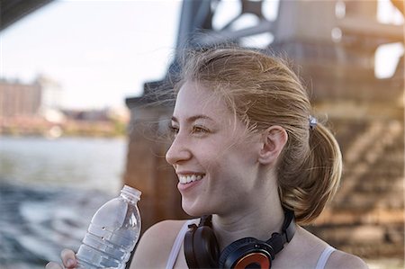 ponte williamsburg - Young woman beside river, wearing headphones around neck, holding water bottle, New York City, USA Foto de stock - Royalty Free Premium, Número: 649-08824087