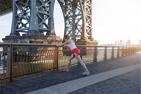 ponte williamsburg - Young woman exercising outdoors, stretching underneath Williamsburg Bridge, New York City, USA Foto de stock - Royalty Free Premium, Número: 649-08824088