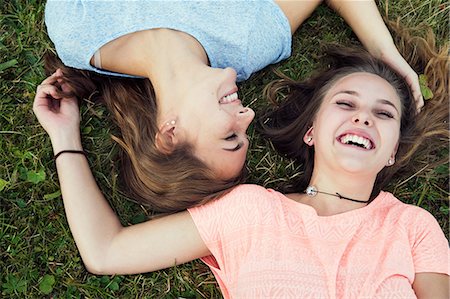 simsearch:649-08824082,k - Overhead portrait of two young women lying and laughing on grass Photographie de stock - Premium Libres de Droits, Code: 649-08824160