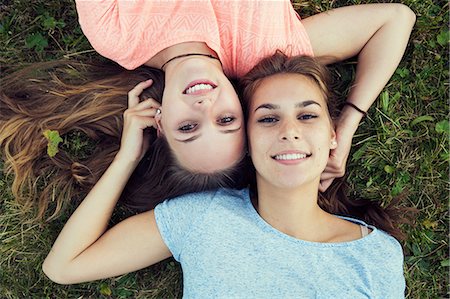 simsearch:649-08824140,k - Overhead portrait of two young women lying on grass Foto de stock - Sin royalties Premium, Código: 649-08824161