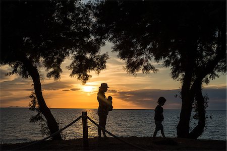 simsearch:649-08824843,k - Silhouette of mother and children by water at sunset, Italy Stock Photo - Premium Royalty-Free, Code: 649-08824219