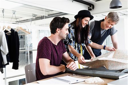 simsearch:649-08824281,k - Colleagues at desk looking at folding map smiling Stock Photo - Premium Royalty-Free, Code: 649-08824268