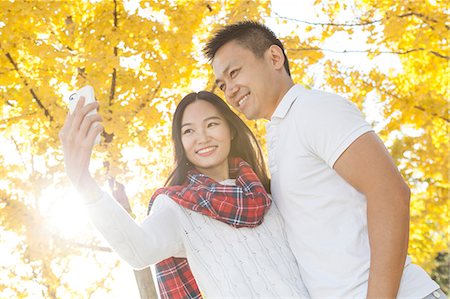 simsearch:649-08824494,k - Young couple taking smartphone selfie in autumnal park, Beijing, China Photographie de stock - Premium Libres de Droits, Code: 649-08824493