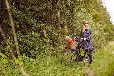 simsearch:649-08232809,k - Young woman on bicycle looking over her shoulder from rural path Stock Photo - Premium Royalty-Free, Code: 649-08824586