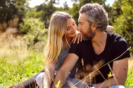 simsearch:649-09061651,k - Romantic couple sitting gazing at each other in rural field Stock Photo - Premium Royalty-Free, Code: 649-08824596