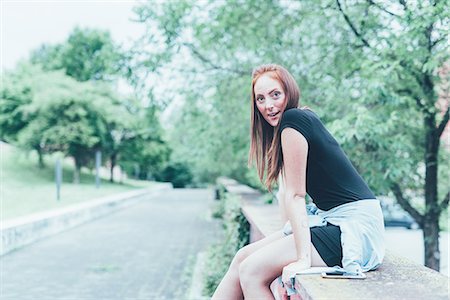 simsearch:649-08824678,k - Portrait of young woman sitting on park wall Stockbilder - Premium RF Lizenzfrei, Bildnummer: 649-08824675