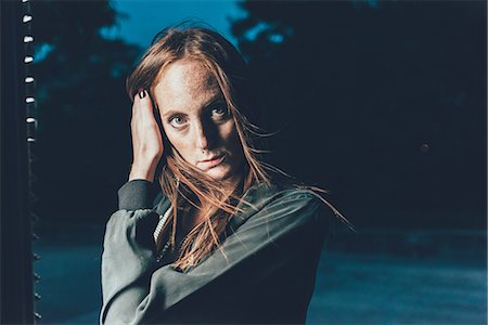 simsearch:649-08824678,k - Portrait of young freckled woman with hand in long red hair at night Stockbilder - Premium RF Lizenzfrei, Bildnummer: 649-08824670