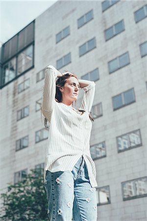 simsearch:649-08560718,k - Low angle view of young woman with hands on head outside office building Photographie de stock - Premium Libres de Droits, Code: 649-08824683