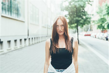 simsearch:649-08824678,k - Portrait of freckled young woman with long red hair standing on city street Stockbilder - Premium RF Lizenzfrei, Bildnummer: 649-08824695