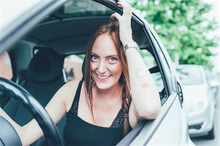 Portrait of young woman with long red hair and freckles at car window Photographie de stock - Premium Libres de Droits, Code: 649-08824698