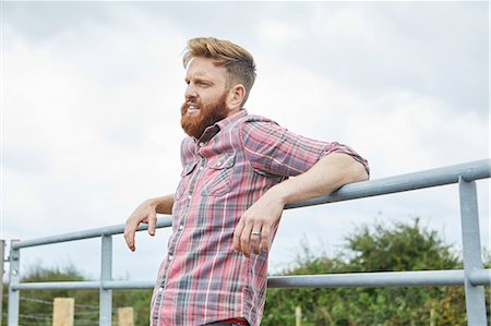 portrait farmer not backlit not flare - Man leaning against farm gate looking away Stock Photo - Premium Royalty-Free, Code: 649-08824787