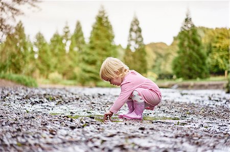 fang - Baby girl wearing rubber boots playing in muddy puddle Foto de stock - Sin royalties Premium, Código: 649-08824813