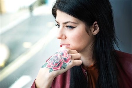 simsearch:649-09123654,k - Young woman with tattoo on hand, looking through window Photographie de stock - Premium Libres de Droits, Code: 649-08824880