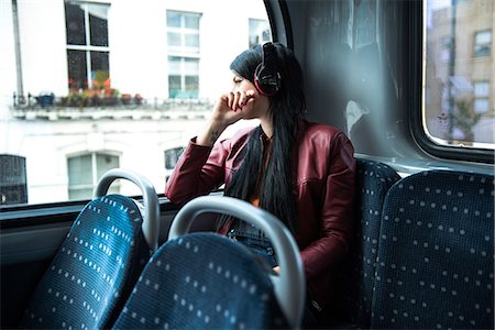 porter (vêtement) - Young woman sitting on bus, wearing headphones, looking out of window Photographie de stock - Premium Libres de Droits, Code: 649-08824881