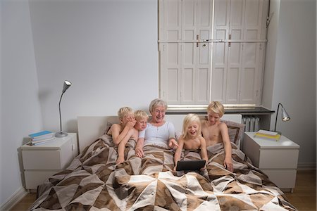 descamisado - Grandmother in bed with grandsons using digital tablet Foto de stock - Sin royalties Premium, Código: 649-08824955