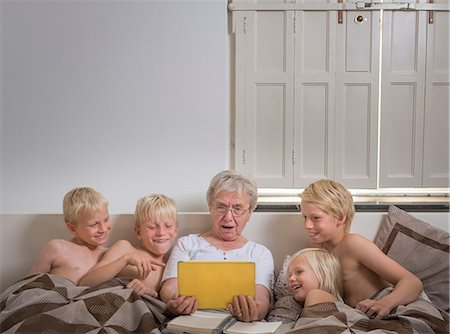 sin camisa - Grandmother in bed with grandsons using digital tablet Foto de stock - Sin royalties Premium, Código: 649-08824956
