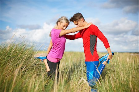 england couple - Couple in tall grass on one leg doing stretching exercises Stock Photo - Premium Royalty-Free, Code: 649-08825297