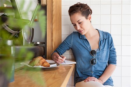 simsearch:649-08825304,k - Young woman sitting at bar in cafée, writing notes in notepad Stock Photo - Premium Royalty-Free, Code: 649-08825302