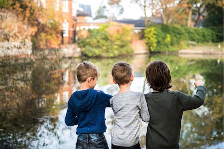 simsearch:700-00186511,k - Three young boys, standing beside lake, rear view Stock Photo - Premium Royalty-Free, Code: 649-08839967