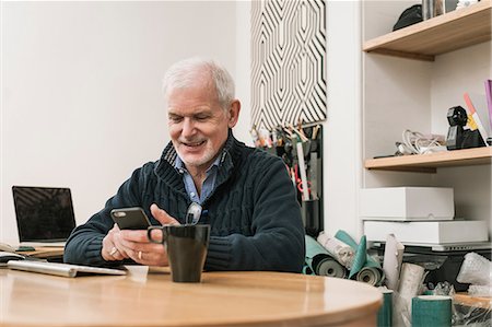 sich herumwälzen - Senior man smiling, using mobile phone at work desk Stockbilder - Premium RF Lizenzfrei, Bildnummer: 649-08840114