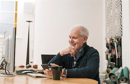 sich herumwälzen - Senior man smiling, using mobile phone at work desk Stockbilder - Premium RF Lizenzfrei, Bildnummer: 649-08840115