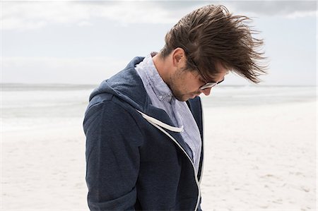 simsearch:851-02962541,k - Young man alone on windswept beach looking down, Western Cape, South Africa Stock Photo - Premium Royalty-Free, Code: 649-08840135