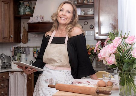 Mature female food blogger using digital tablet in traditional Italian kitchen Stock Photo - Premium Royalty-Free, Code: 649-08840136